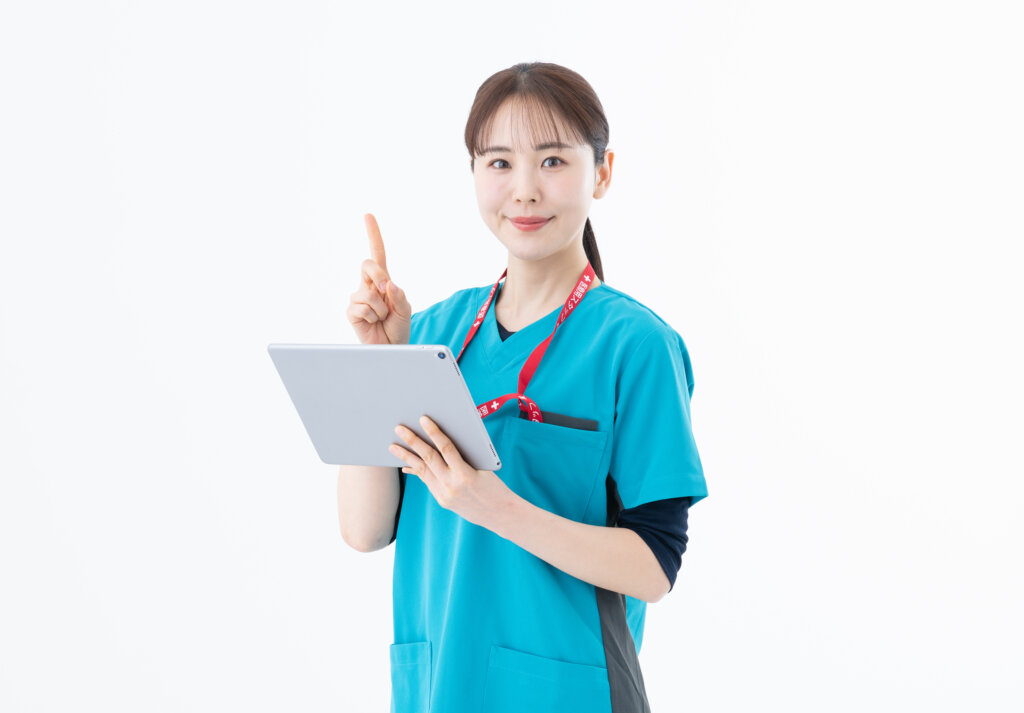 タブレットを持って説明する医療スクラブ姿の女性スタッフ
