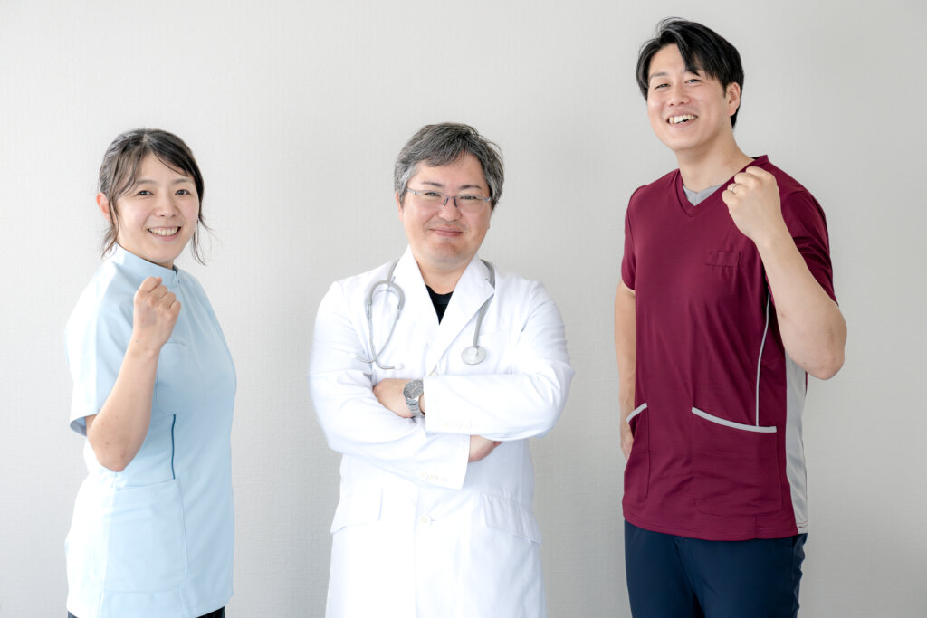 医療現場で働く看護師と医師、ユニフォーム姿でガッツポーズをする3人