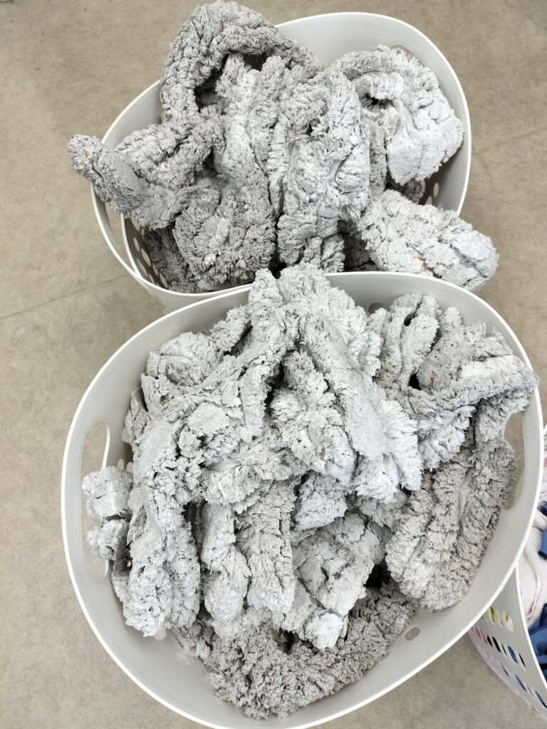 洗濯後の業務用モップをカゴに並べた様子