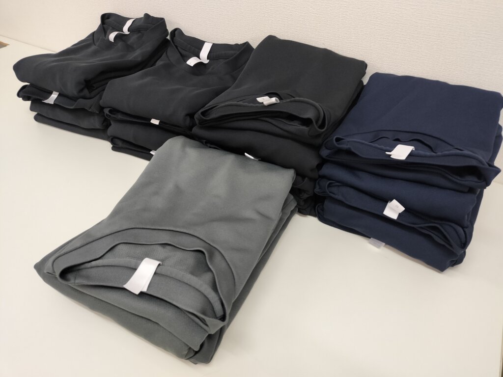 サイズ・色別にたたまれた施術着