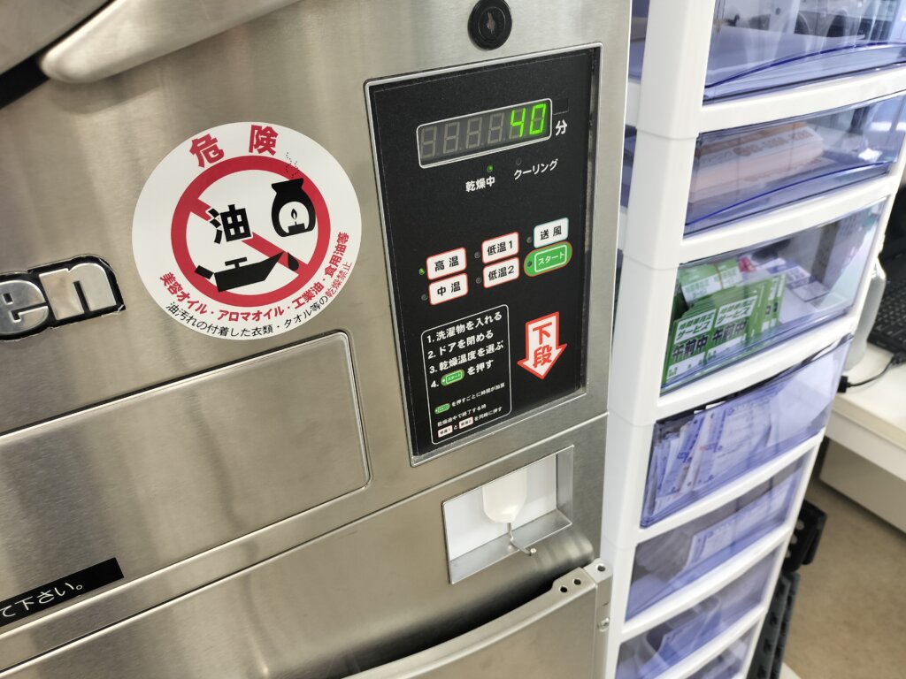 乾燥機の操作パネルとオイル付着注意の警告ステッカー