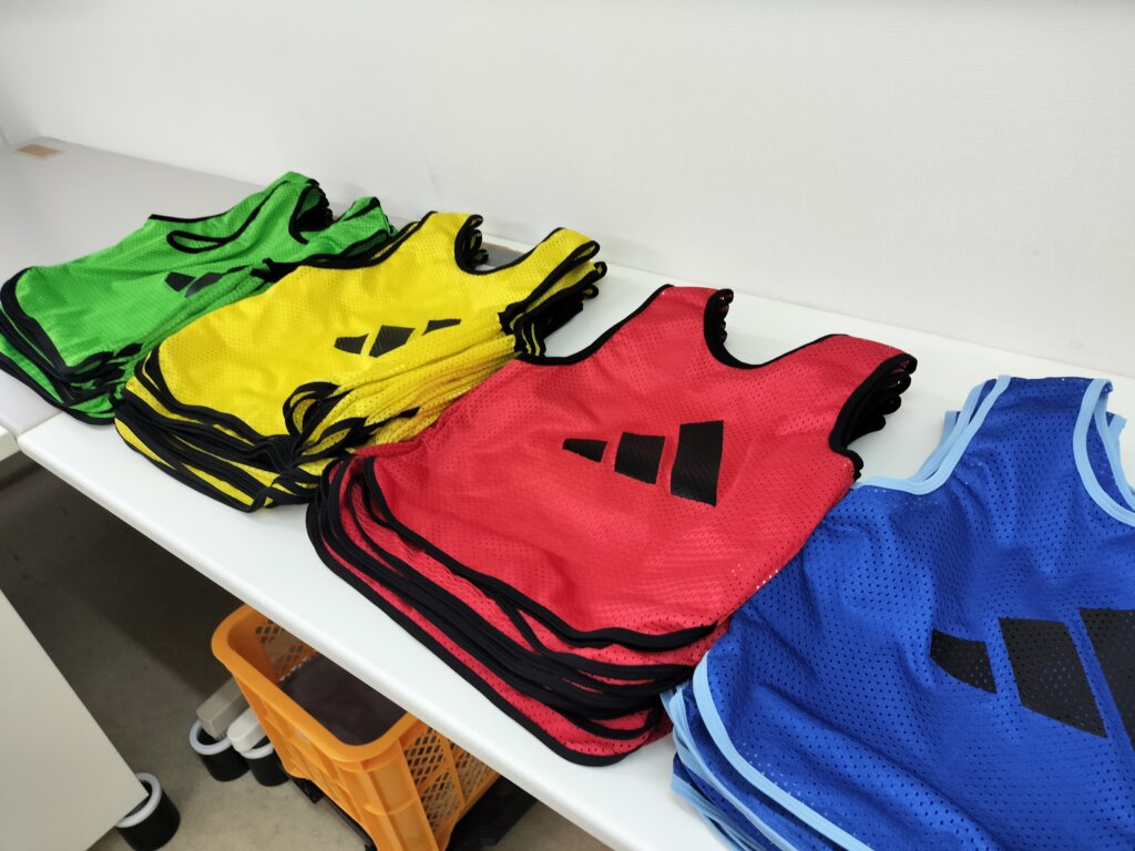 洗濯後にテーブル上で色ごとに広げられたメッシュビブス