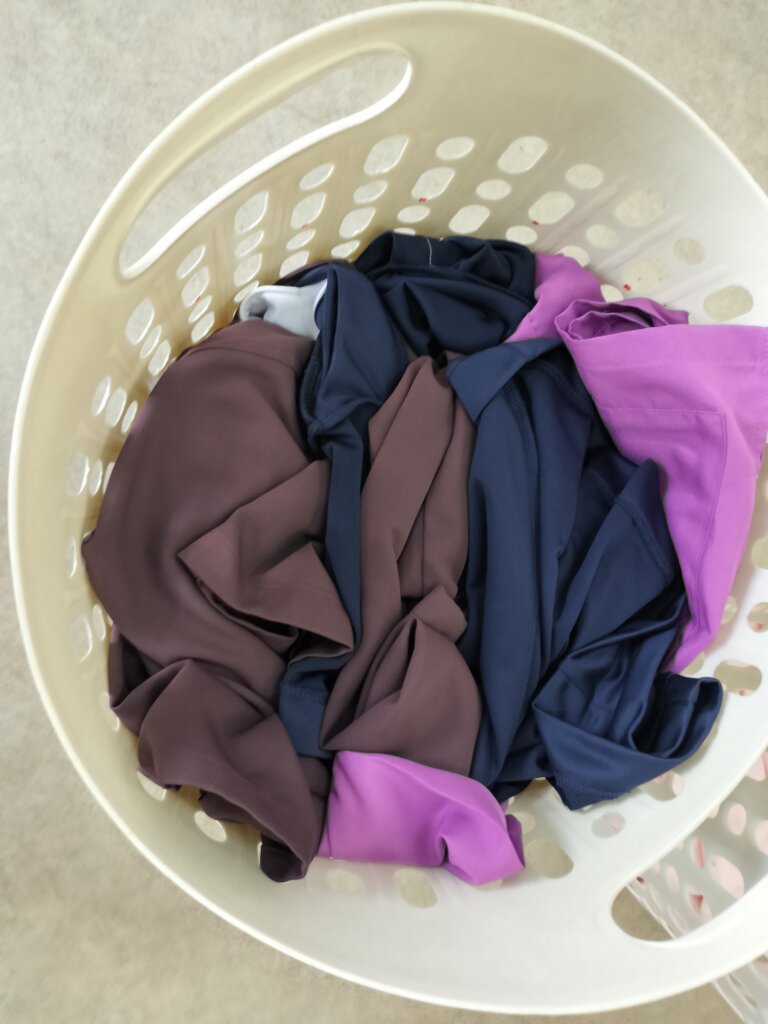 スクラブ上下の洗濯物をまとめてランドリーバスケットに入れた様子(東京都内 医療法人さまより)
