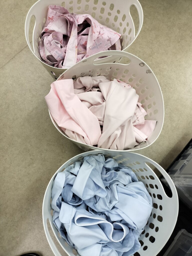 色ごとに仕分けられた白衣やナースワンピース。洗濯代行で効率的にまとめ洗い。