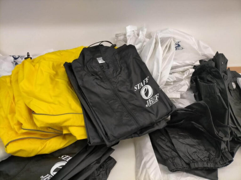 黒と黄色のスタッフ用ウィンドブレーカーが積み重ねられている様子