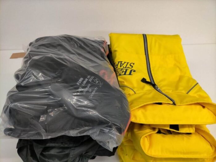 袋詰めされた黒いウィンドブレーカーと黄色のスタッフウェアが並んでいる写真