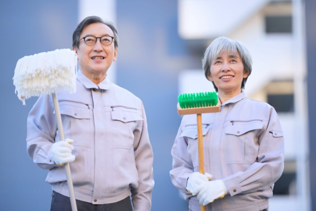 清掃スタッフが清掃用具を持って立っているイメージ写真