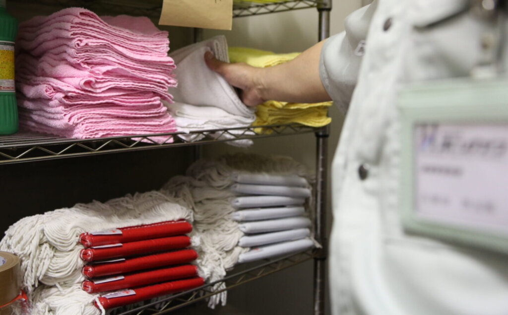 清掃会社の棚にモップ雑巾が綺麗に積み上げられてる