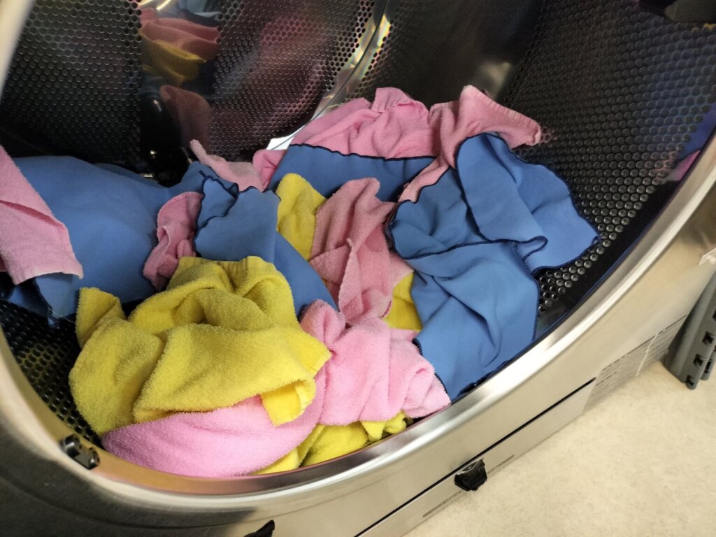 タオルや雑巾が業務用乾燥機に入っている工程写真