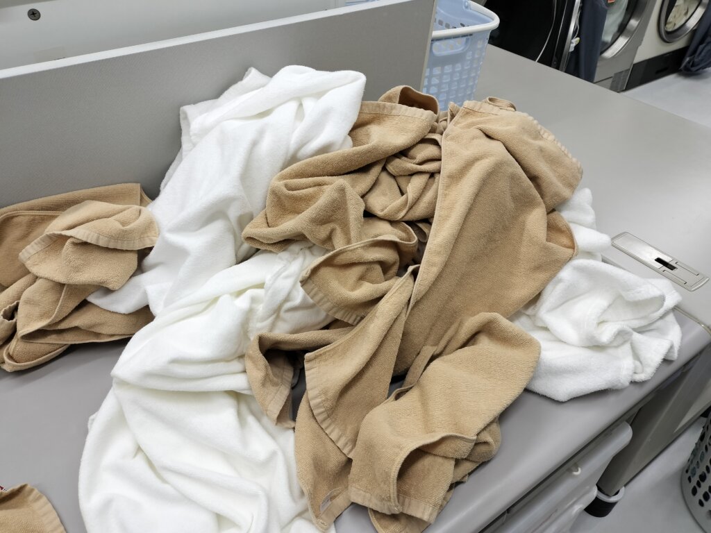 乾燥後たたみ台に山積みになったフェイスタオル