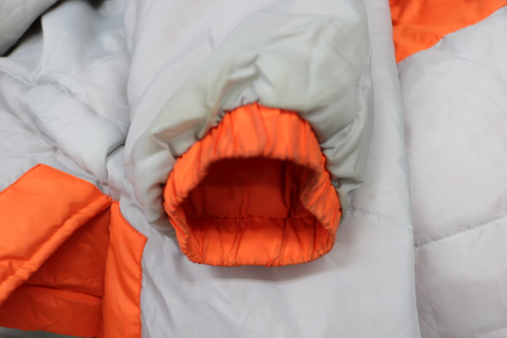 ベンチコートの袖口部分を拡大し汚れや状態を確認している様子