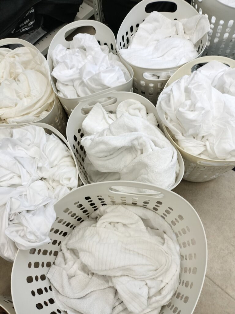 タオル、バスタオル、シーツ類が洗濯籠に入ってる