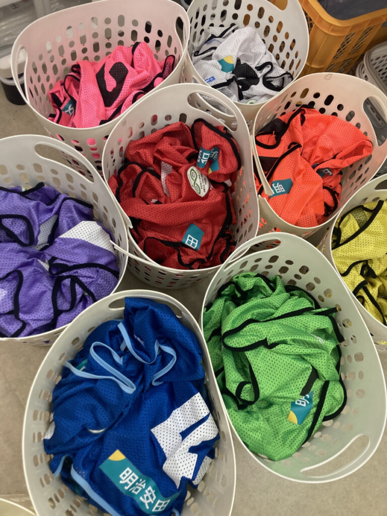 洗濯後色分けされたビブスが洗濯籠に入ってる。