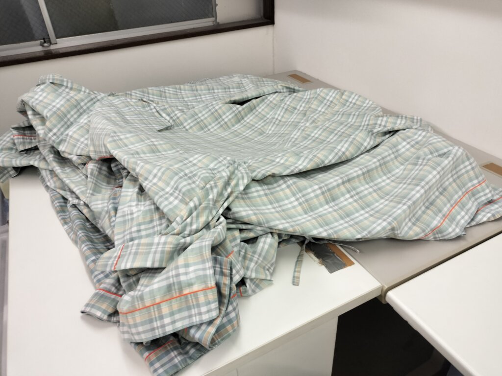 乾燥後の検査衣が台に広げられてる重なってる