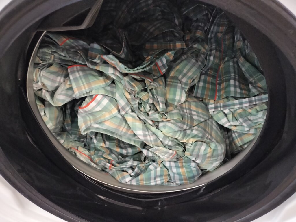 検査衣が洗濯機に入れられてる。これから洗濯される