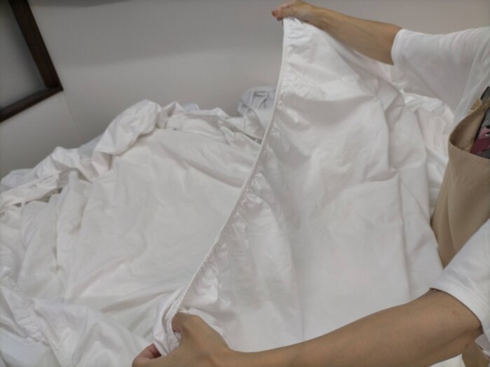 洗濯後、リネン類を手たたみしてる