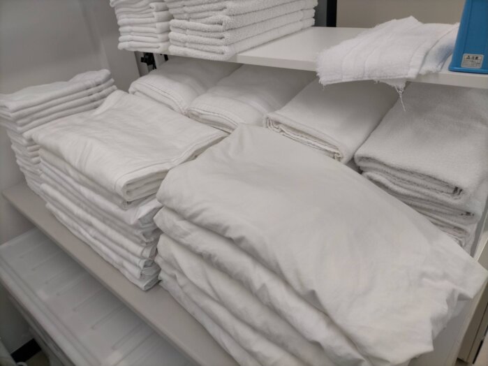 シーツ、布団カバー、バスタオル、などリネン類が洗濯後たたまれてる