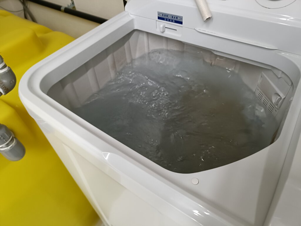 洗濯機にオイル付きタオルが入って回ってる